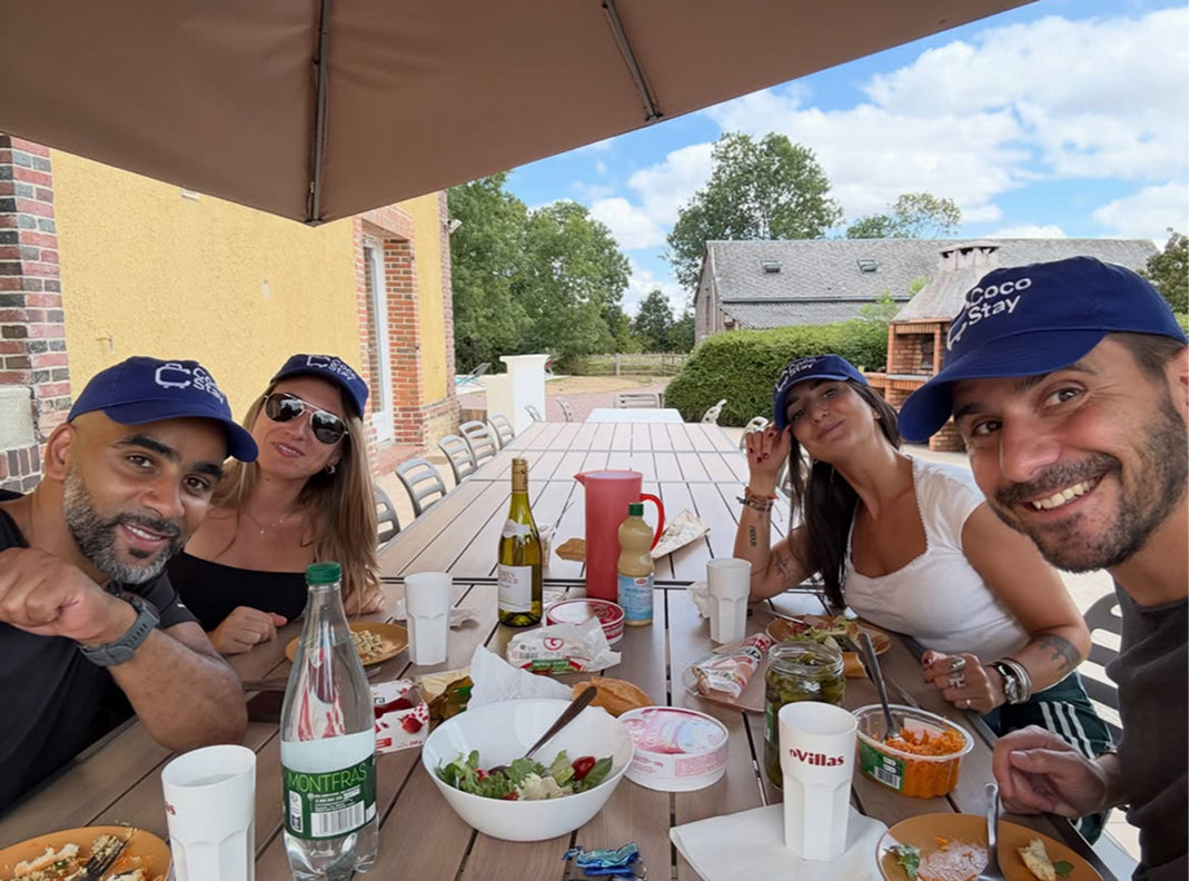 La CocoTeam en casquettes CocoStay, en selfie autour d'une table en terrasse